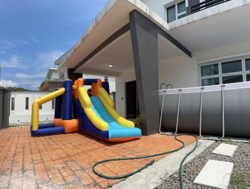 a playground in the backyard of a house at Fun Villa 6rm 12 to 22 pax Wifi Netflix BBQ SteamBoat Games Beach Water Park in Desaru
