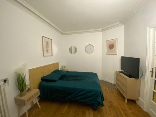 une chambre avec un lit et une télévision à écran plat dans l'établissement L'étoile de duhesme, à Paris