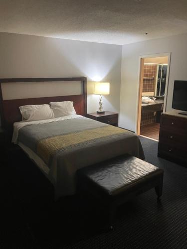 a hotel room with a large bed and a television at Apm Inn & Suites in Hagerstown