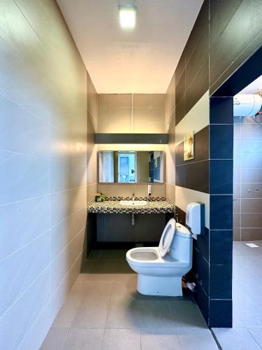 a bathroom with a toilet and a sink at Lux Villa 6rm 12 to 22 pax Wifi Netflix BBQ SteamBoat Games Beach Water Park in Desaru
