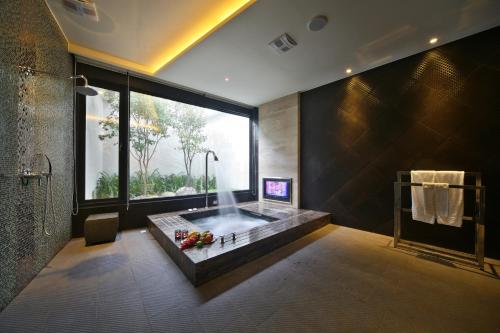 a bathroom with a tub with a large window at Han Guan Motel in Taichung
