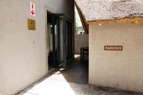 a sign that says parking on the side of a building at Chobe House Villa and Chalets in Kasane