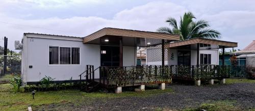 a small white house with a porch at Yin Garden Lodge Fortuna in Fortuna