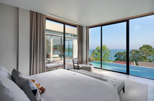 a bedroom with a white bed and a pool at Phuket V Building 19 Villas with Andaman Sea View Private Swimming Pool and Spa in Ban Ao Makham