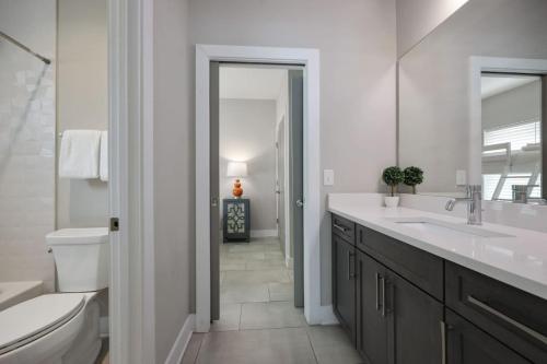 un bagno con lavandino, WC e specchio di Two Townhomes - Hot Tubs and Rooftop Balconies a Nashville