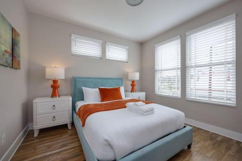 una camera da letto con un letto con cuscini bianchi e arancioni di Two Townhomes - Hot Tubs and Rooftop Balconies a Nashville