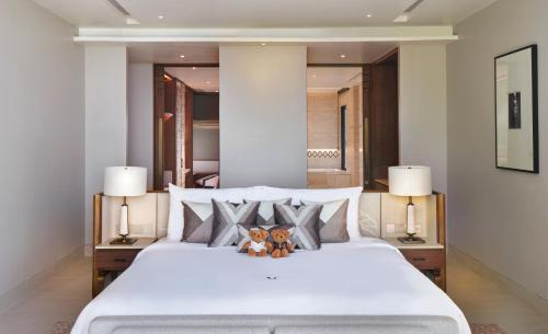 a bedroom with a white bed with two teddy bears on it at Phuket V Building 19 Villas with Andaman Sea View Private Swimming Pool and Spa in Ban Ao Makham