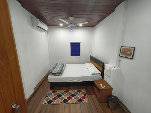 a small room with a bed and a ceiling at Blue Bell Homestay in Udupi