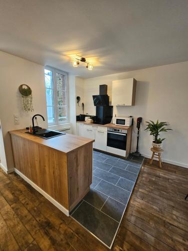 - une cuisine avec un îlot en bois dans l'établissement L'authentique - Appartement 4, à Loudéac
