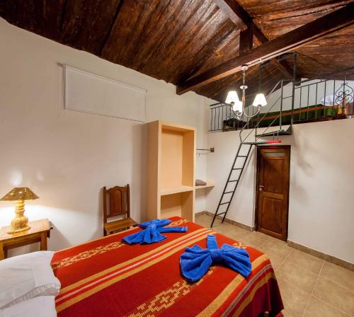 a bedroom with a bed with blue bows on it at Casa Grande Hotel Tilcara in Tilcara