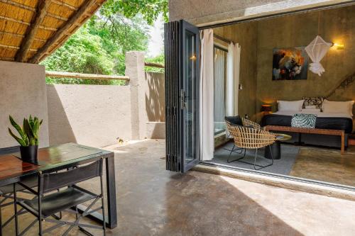 a bedroom with a bed and a desk and a table at Chobe House Villa and Chalets in Kasane