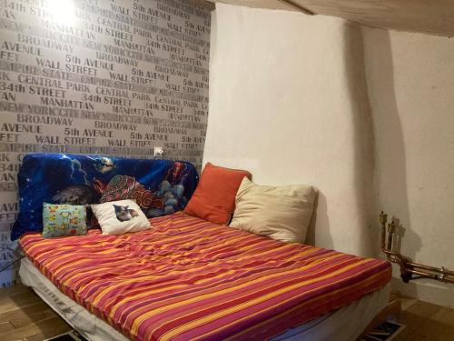 une chambre avec un lit avec des oreillers dessus dans l'établissement Longère en bordure de bois, à Maisonnay