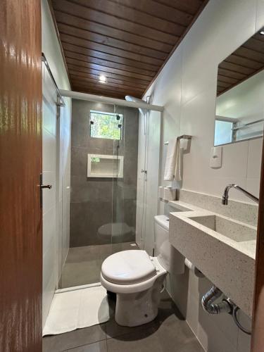 a bathroom with a toilet and a shower and a sink at Pousada Chalé Flor de Hibisco 2 in Penha
