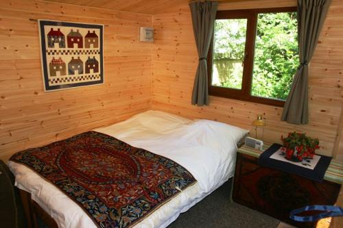a bedroom with a bed in a log cabin at Dogwood Cabin in Rye