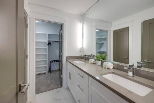 a bathroom with two sinks and a large mirror at Two Elegant Townhomes Perfect for Large Groups in Nashville