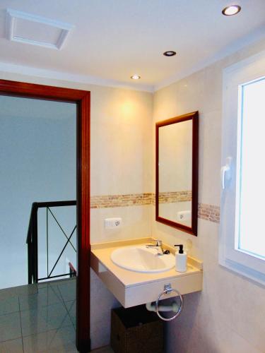 a bathroom with a sink and a mirror at Casita Playa Castillo "Vivienda 3B" in Caleta De Fuste