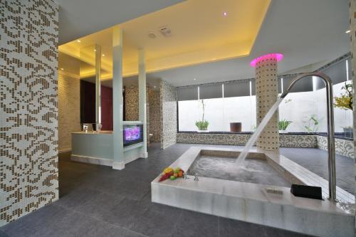 a bathroom with a tub with a tv in it at Han Guan Motel in Taichung