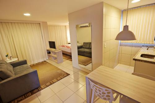 a living room with a couch and a room with a bed at Comfort Hotel & Suites Natal in Natal