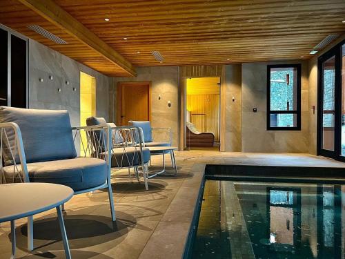 - un salon avec une piscine et des chaises dans l'établissement Appartement chic 4* avec SPA, parking, WIFI et terrasse - FR-1-352-86, à Bourg-Saint-Maurice