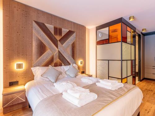 une chambre avec un lit blanc avec des serviettes dessus dans l'établissement Appartement chic 4* avec SPA, parking, WIFI et terrasse - FR-1-352-86, à Bourg-Saint-Maurice