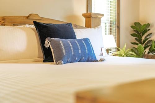 a bed with a blue and white pillow on it at Red Rock Vista Cabin- Relaxing Spring Getaway in Jasper