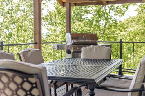 an outdoor table and chairs with a grill on a deck at Red Rock Vista Cabin- Relaxing Spring Getaway in Jasper