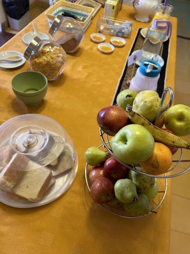 a table with a bowl of apples and other food at Casa Grande Hotel Tilcara in Tilcara