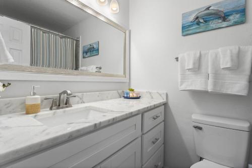 a bathroom with a sink and a mirror and a toilet at Coastal Retreat by the Beach in Long Beach
