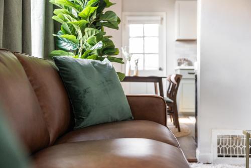 a brown couch with a green pillow in a living room at Mid-Century Modern Retreat in Little Italy in Cleveland