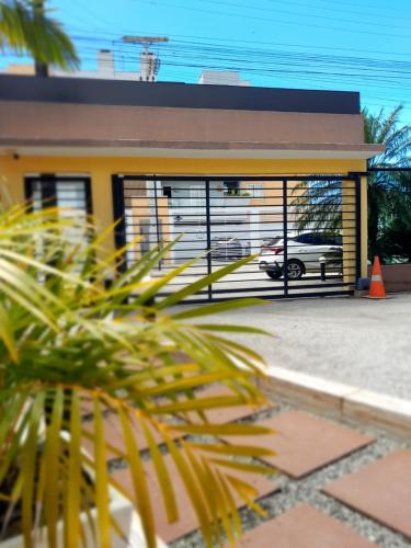 a building with a parking lot with a car in it at Pousada Anjos - à 2 quadras do mar in Matinhos