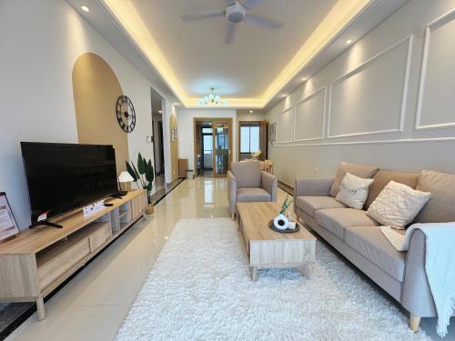 a living room with a couch and a tv at TheBess Hotel Tokyo is located adjacent to Singapore and offers a sea viewIt is a family business smart room with the sea view of Princess Bay富力公主湾 in Johor Bahru