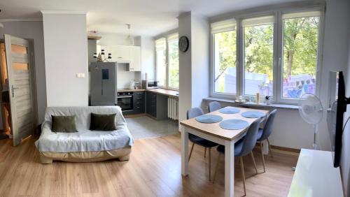 a kitchen and living room with a table and a couch at Studio Zielony Ryneczek in Zamość