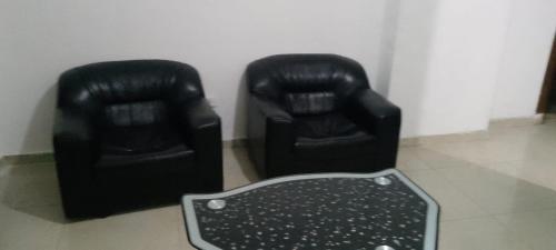 zwei schwarze Ledersessel, die nebeneinander stehen in der Unterkunft Ara Home in Amman