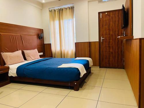 a bedroom with a bed with a wooden headboard and a television at White Portico in Thekkady