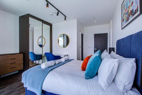 a bedroom with a large white bed with colorful pillows at Legacy Punks by Artsy in London