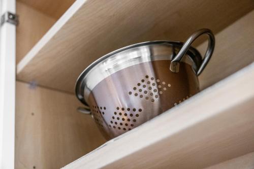 a metal pot on a shelf in a drawer at Mid-Century Modern Retreat in Little Italy in Cleveland