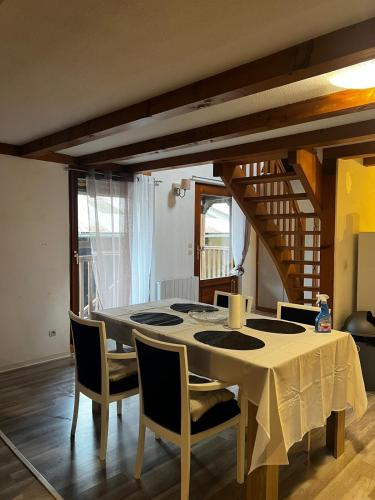 une salle à manger avec une table et des chaises blanches dans l'établissement Charmant duplex trois pièces paisible, à Berstett
