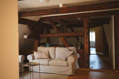 a living room with a white couch and wooden beams at Palitz No 17 - venkovské stavení in Lipová