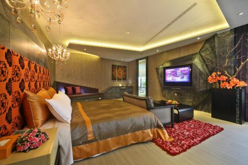 a hotel room with a bed and a tv at Han Guan Motel in Taichung