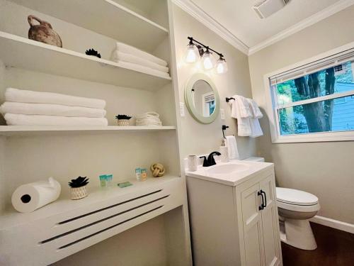 a white bathroom with a sink and a toilet at The Charming Location in Waycross