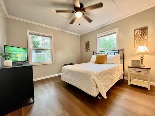 a bedroom with a bed and a ceiling fan at The Charming Location in Waycross
