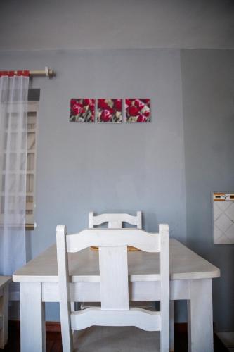 a dining room table and two white chairs at GARDEN HOLiDAY in Antsirabe