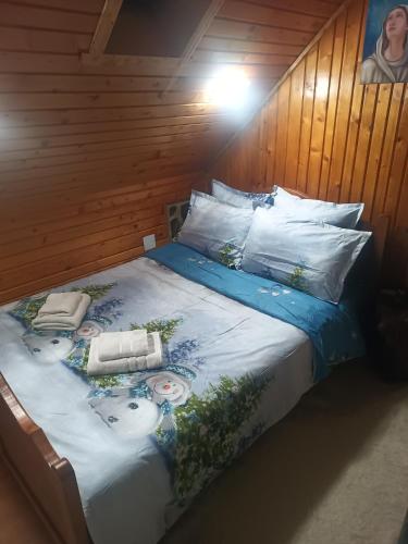 a bed with two pillows on it in a room at Coliba Padurarului in Porumbacu de Jos