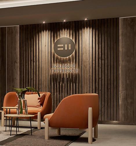 a lobby with two orange chairs and a table at EHBoutique Experience in El Calafate