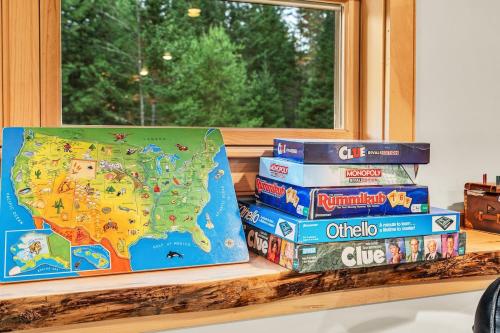 a stack of books sitting on a shelf next to a window at Private Chalet with Fireplace Hottub and Game Room in Bethel