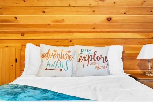 a bedroom with a bed with white sheets and pillows at Private Chalet with Fireplace Hottub and Game Room in Bethel