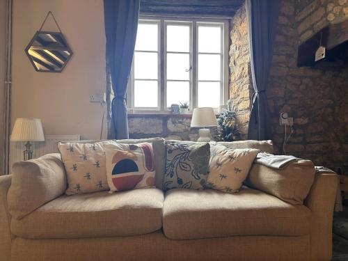 a couch in a living room with a window at Rustic Cottage in the countryside in Broadwindsor
