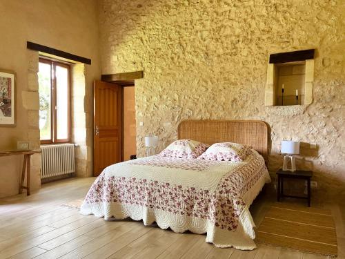 a bedroom with a bed and a stone wall at Domaine sur les coteaux de Loupiac in Loupiac-de-Cadillac