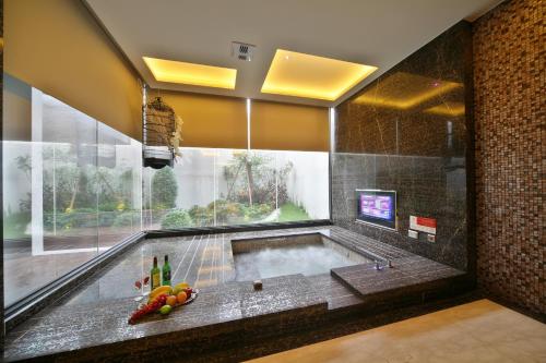 a jacuzzi tub in a room with a television at Han Guan Motel in Taichung