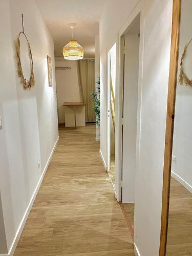 a hallway with white walls and wood floors at Évasion douce,SPA Balnéo in Sainte-Foy-la-Grande